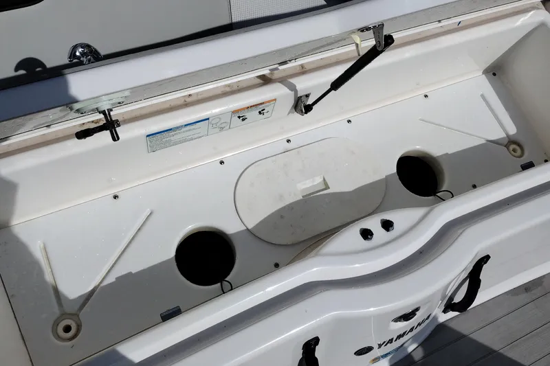 Slide: The Image of 2023 Yamaha AR250 boat storage compartment with open lid and visible interior features. - 34