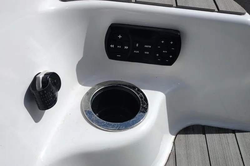 Slide: The Image of 2023 Yamaha AR250 boat console with audio controls and cup holder. - 35