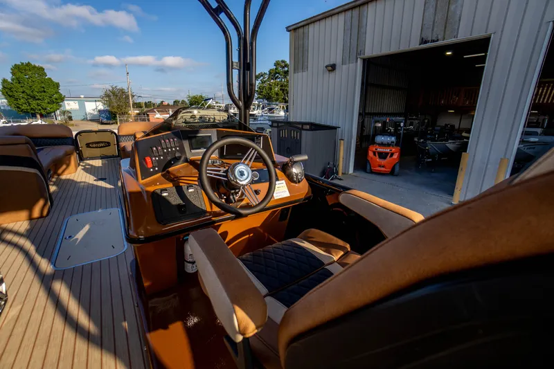 Slide: The Image of 2026 Aloha Paradise 300 Sundeck boat interior with steering wheel and seating. - 16
