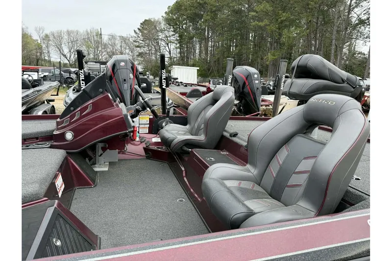 Slide: The Image of 2022 Nitro Z20 Pro boat interior with gray seats and maroon accents, parked outdoors. - 4