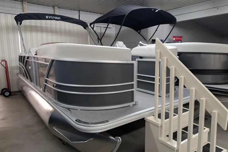 The Image of 2026 Sylvan Mirage 820 Cruise pontoon boat displayed indoors with canopy. - 0