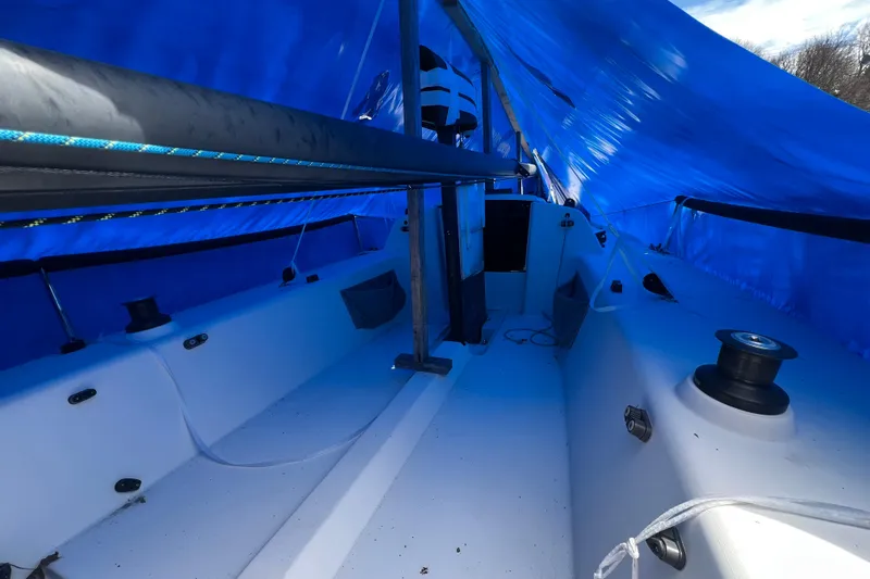 Slide: The Image of 2013 J Boats J/70 sailboat interior under blue tarp, showcasing deck and rigging. - 11