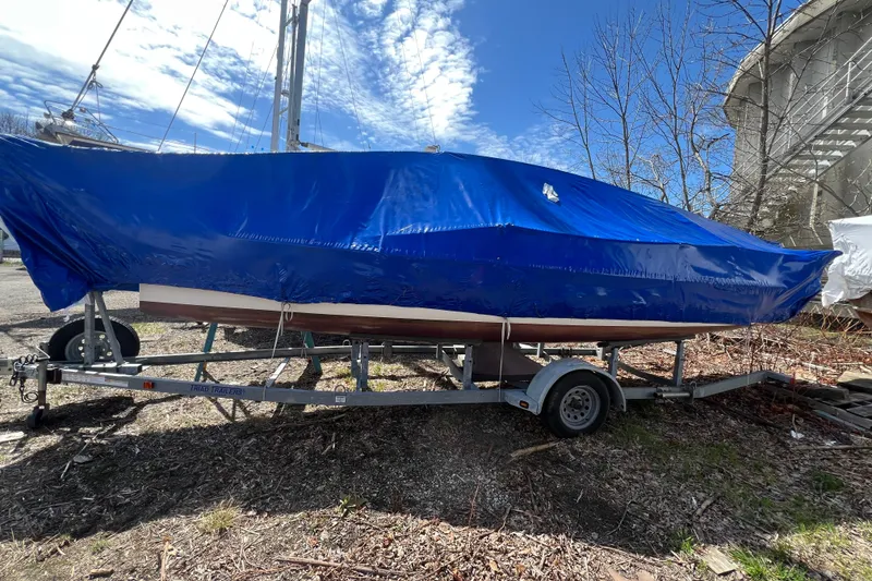 Slide: The Image of 2013 J Boats J/70 sailboat covered in blue tarp on a trailer outdoors. - 7