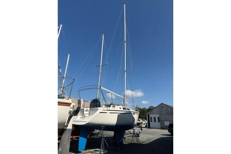 Slide: The Image of 1990 Hunter 33.5 sailboat on stands, clear sky background. - 6