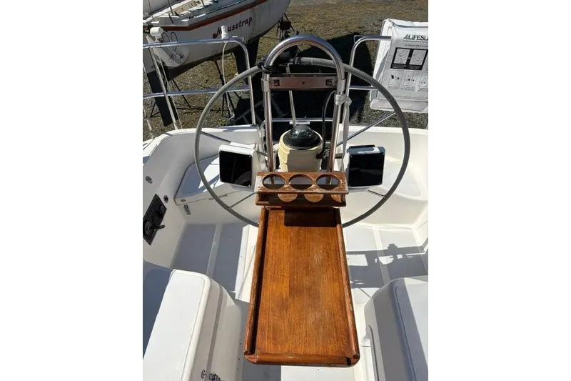 Slide: The Image of Cockpit of 1990 Hunter 33.5 sailboat with wooden table and steering wheel. - 8
