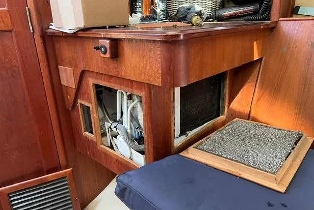 Slide: The Image of Interior of a 1990 Hunter 33.5 sailboat showing wooden cabinetry and exposed wiring. - 9