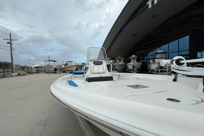 Slide: The Image of 2015 Blue Wave 2000 PureBay boat displayed outside a showroom under cloudy skies. - 13