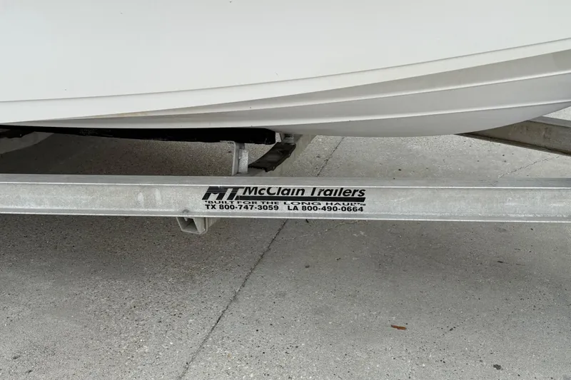 Slide: The Image of Trailer supporting a 2015 Blue Wave 2000 PureBay boat, McClain Trailers branding visible. - 14