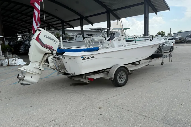 Slide: The Image of 2015 Blue Wave 2000 PureBay boat with Evinrude motor on trailer in marina setting. - 3