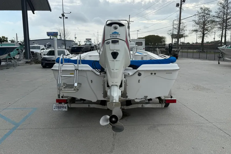 Slide: The Image of 2015 Blue Wave 2000 PureBay boat with Evinrude motor, parked on a trailer. - 4