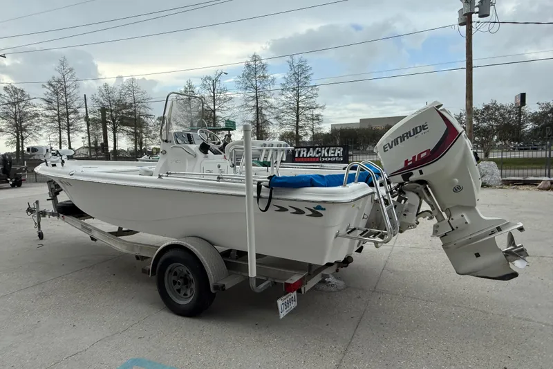 Slide: The Image of 2015 Blue Wave 2000 PureBay boat with Evinrude motor on trailer, parked outdoors. - 5