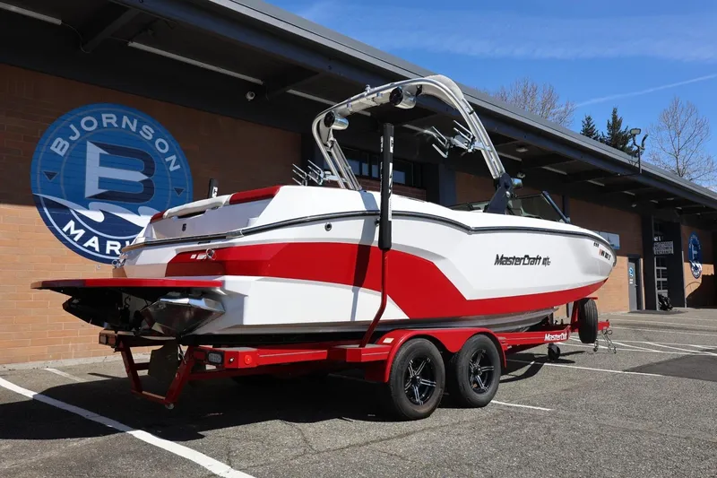 Slide: The Image of 2021 MasterCraft NXT24 boat on trailer outside Bjornson Marine building. - 15