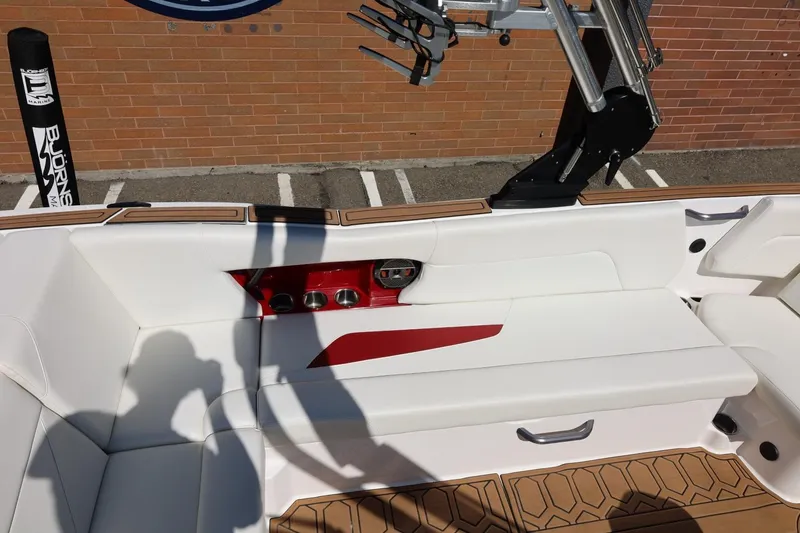 Slide: The Image of Interior of 2021 MasterCraft NXT24 boat with white seating and red accents. - 22