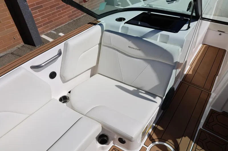Slide: The Image of 2021 MasterCraft NXT24 boat interior with white seating and wood accents. - 23