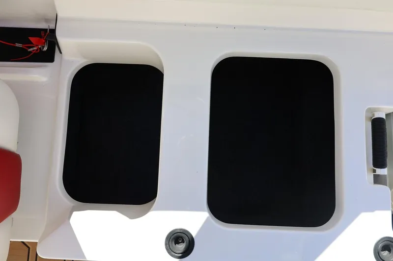 Slide: The Image of 2021 MasterCraft NXT24 boat storage compartments with black interior and white exterior. - 28