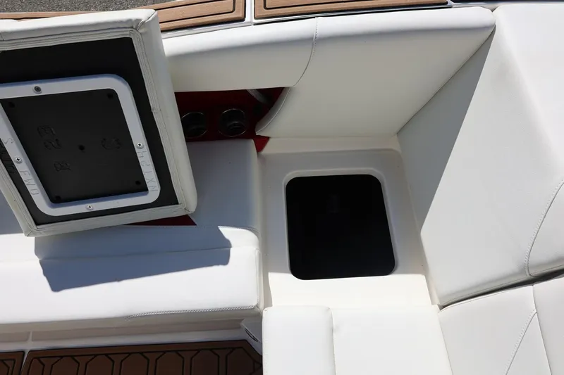 Slide: The Image of 2021 MasterCraft NXT24 boat interior with open storage compartment and white seating. - 29