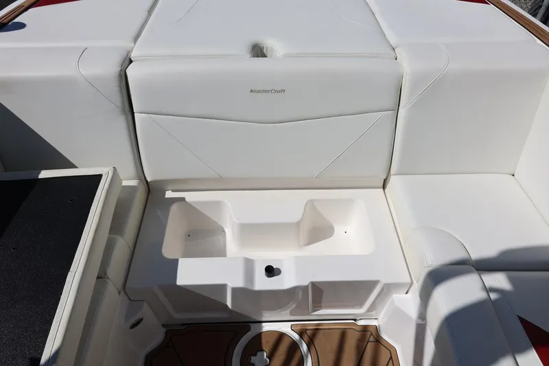 Slide: The Image of 2021 MasterCraft NXT24 boat interior with white seating and storage compartment. - 30