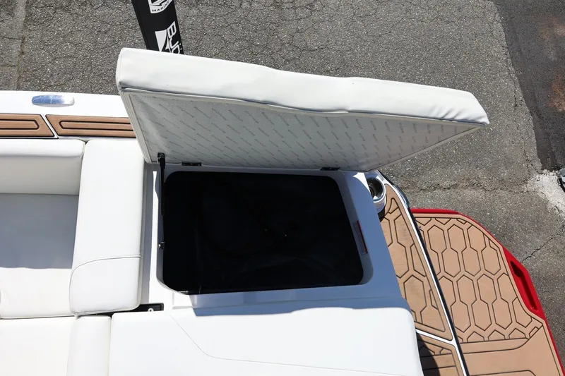 Slide: The Image of Open storage compartment on 2021 MasterCraft NXT24 boat with cushioned seating. - 31