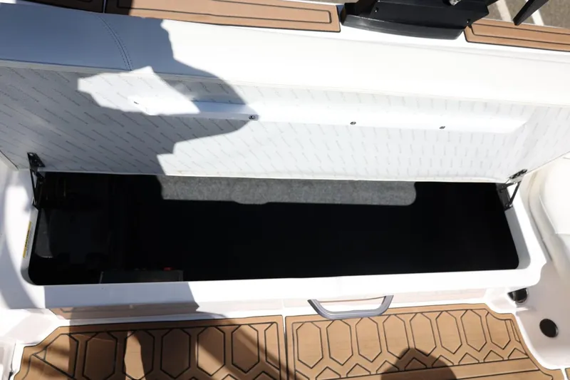 Slide: The Image of Open storage compartment on 2021 MasterCraft NXT24 boat with teak flooring. - 33
