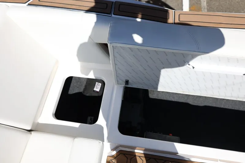 Slide: The Image of 2021 MasterCraft NXT24 boat interior storage compartment with white and brown seating. - 34