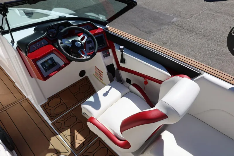 Slide: The Image of 2021 MasterCraft NXT24 boat interior with red and white seating, modern dashboard, and wood accents. - 38