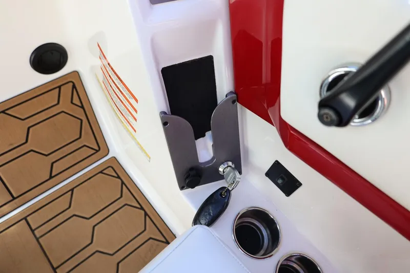 Slide: The Image of Interior detail of 2021 MasterCraft NXT24 boat, featuring key ignition and cup holders. - 47