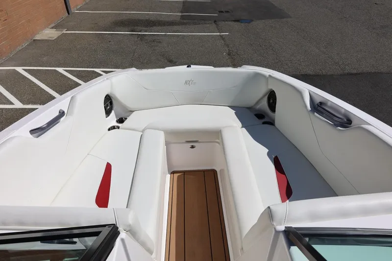 Slide: The Image of 2021 MasterCraft NXT24 boat interior with white seating and wood flooring. - 50
