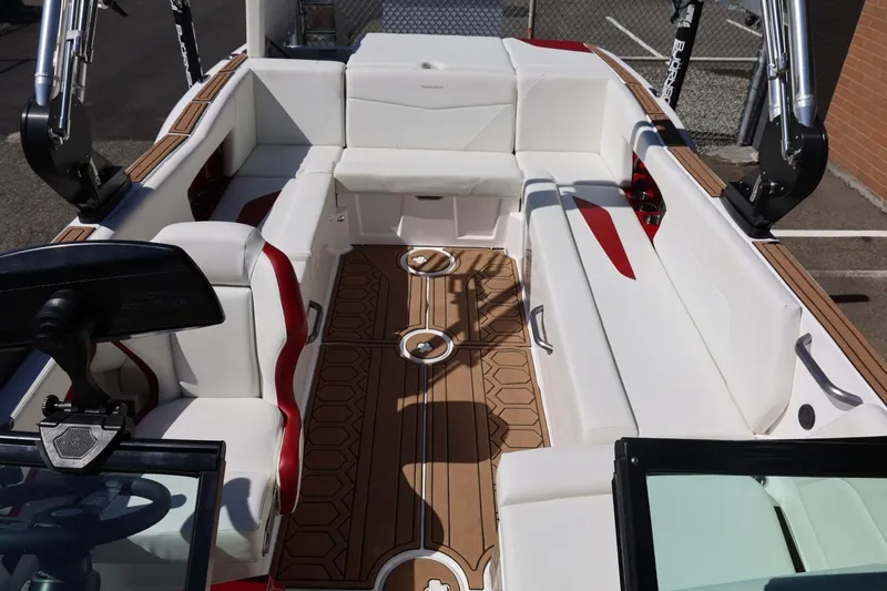 Slide: The Image of 2021 MasterCraft NXT24 boat interior with white seating and wooden flooring. - 58
