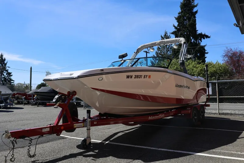 Slide: The Image of 2021 MasterCraft NXT24 boat on trailer in parking lot under clear sky. - 8