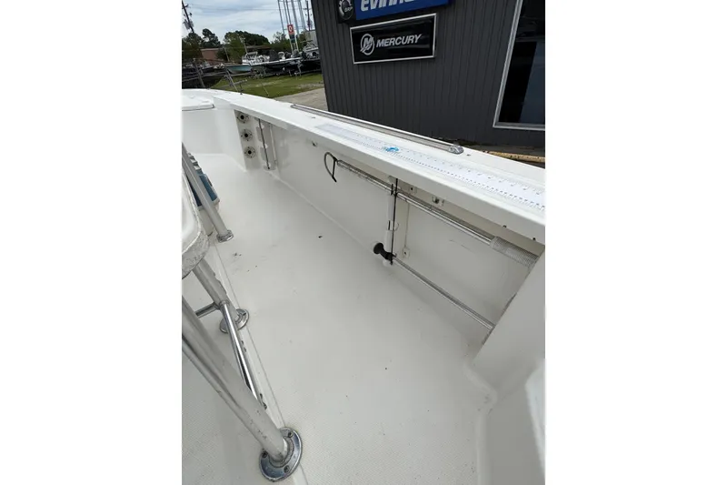 Slide: The Image of 2010 Triton 240 LTS Pro boat interior with clean deck and fishing rod holders. - 13
