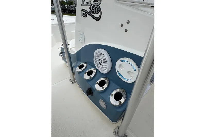 Slide: The Image of 2010 Triton 240 LTS Pro boat console with rod holders and washdown system. - 16