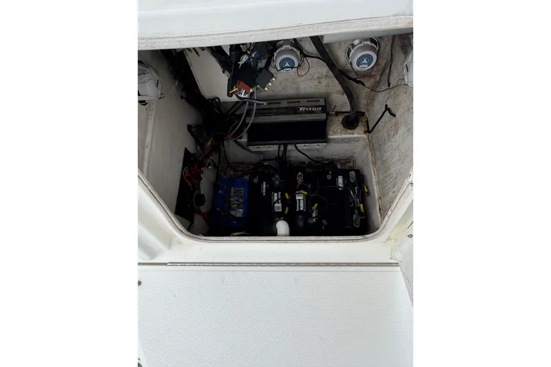 Slide: The Image of 2010 Triton 240 LTS Pro boat battery compartment with wiring and components. - 19