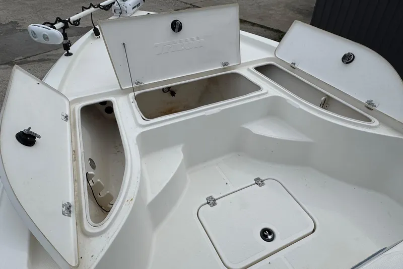 Slide: The Image of 2010 Triton 240 LTS Pro boat with open storage compartments and trolling motor. - 22