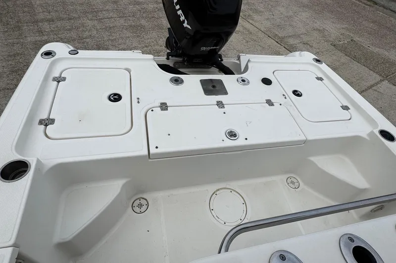 Slide: The Image of 2010 Triton 240 LTS Pro boat deck with storage compartments and Mercury engine. - 7