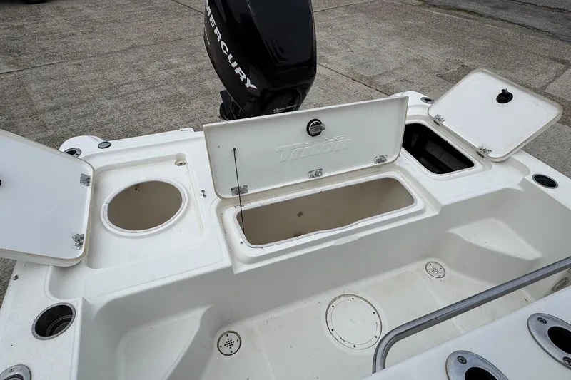 Slide: The Image of 2010 Triton 240 LTS Pro boat with open storage compartments and Mercury engine. - 8