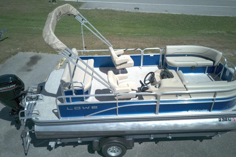 The Image of 2024 Lowe Ultra 200 Cruise pontoon boat with seating and Mercury outboard motor. - 0