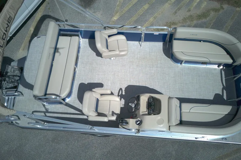 Slide: The Image of 2024 Lowe Ultra 200 Cruise pontoon boat interior with beige seating and steering console. - 4