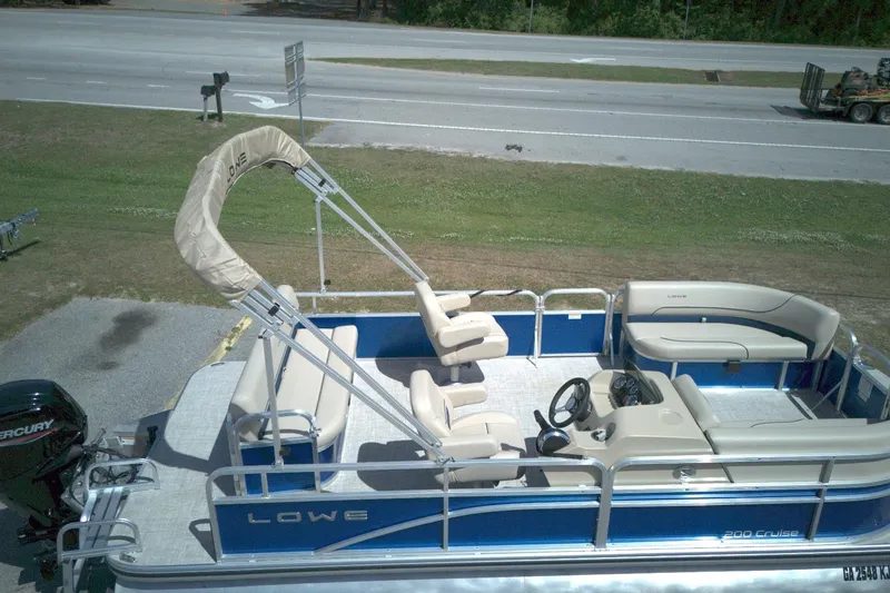 Slide: The Image of 2024 Lowe Ultra 200 Cruise pontoon boat with beige seating and blue exterior. - 8