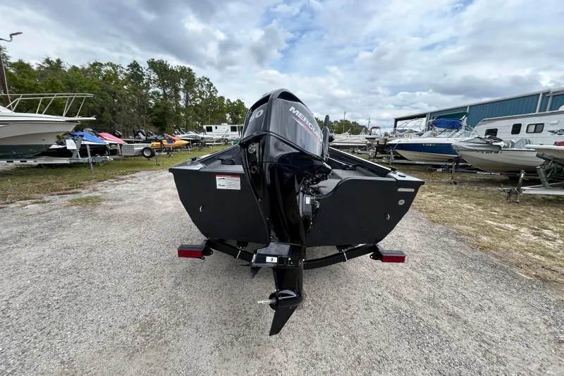 The Image of 2026 Crestliner 1650 Discovery Tiller boat with Mercury engine in a boatyard. - 1