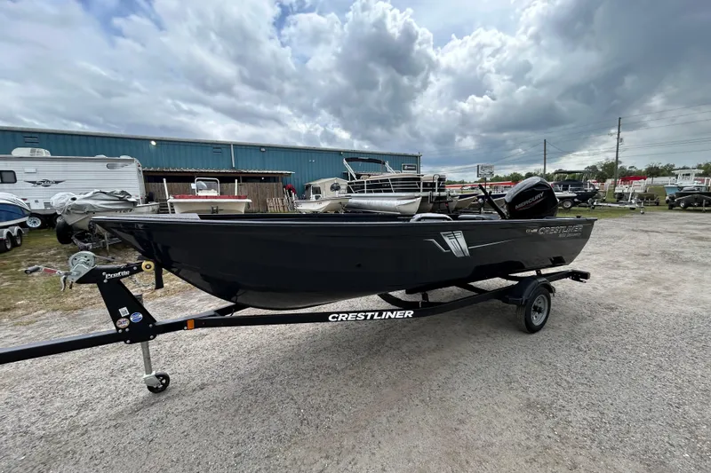 Slide: The Image of 2026 Crestliner 1650 Discovery Tiller boat on trailer, parked outdoors under cloudy sky. - 3