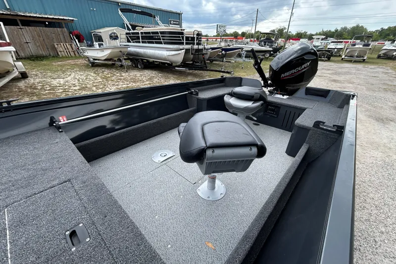 Slide: The Image of 2026 Crestliner 1650 Discovery Tiller boat with Mercury engine, parked outdoors. - 6