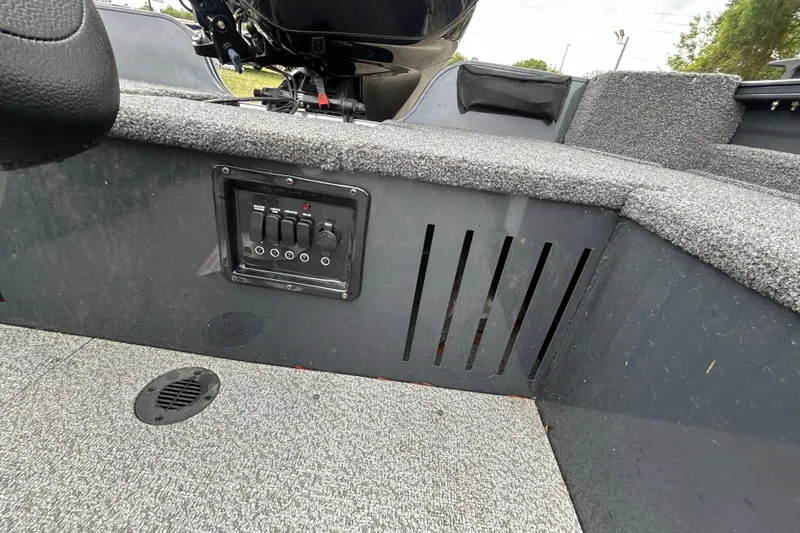 Slide: The Image of 2026 Crestliner 1650 Discovery Tiller boat interior with control panel and carpeted flooring. - 8