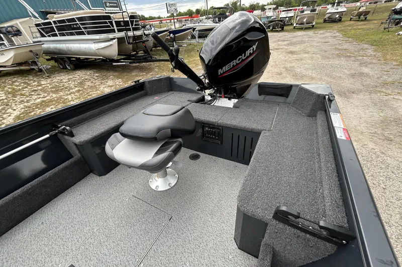 Slide: The Image of 2026 Crestliner 1650 Discovery Tiller boat interior with Mercury engine, featuring seating and storage. - 9