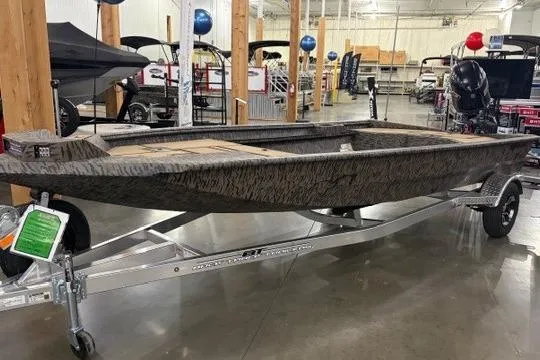 The Image of 2026 Xpress X18DB boat on trailer in showroom, featuring camouflage design. - 0