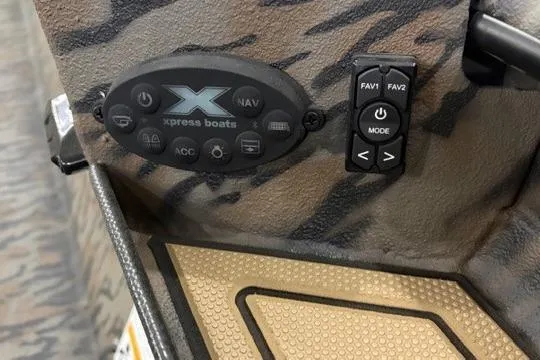 Slide: The Image of Control panel of 2026 Xpress X18DB boat with camouflage design and navigation buttons. - 2