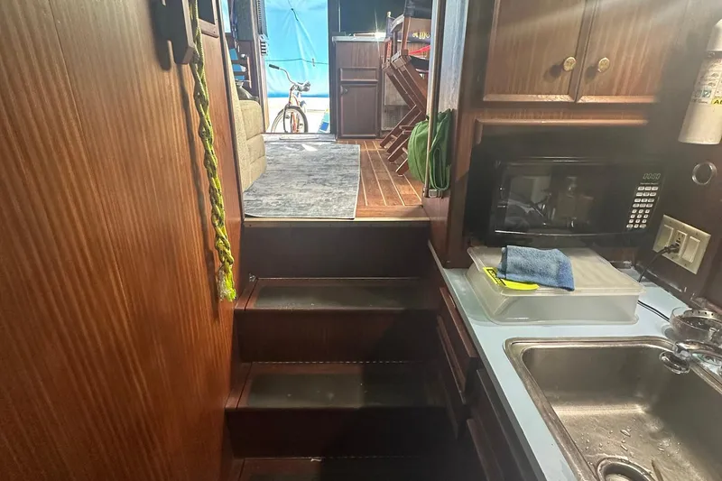 Slide: The Image of Interior of 1981 Hatteras 43 Convertible yacht, featuring kitchen and stairs to living area. - 18