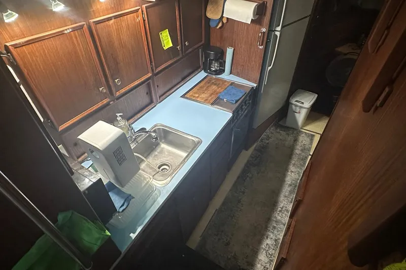 Slide: The Image of 1981 Hatteras 43 Convertible yacht kitchen with wooden cabinets and modern appliances. - 19