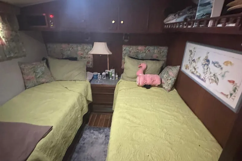 Slide: The Image of Cozy cabin interior of 1981 Hatteras 43 Convertible with twin beds and decorative pillows. - 23