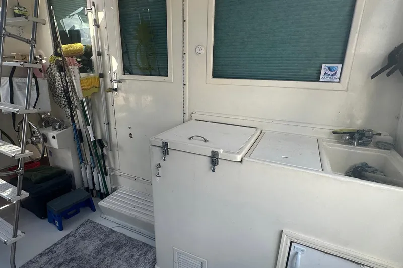 Slide: The Image of 1981 Hatteras 43 Convertible boat interior with fishing gear and storage compartments. - 5