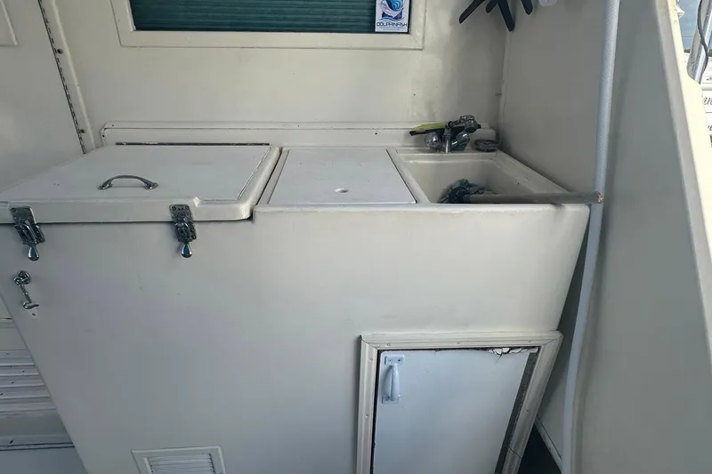 Slide: The Image of 1981 Hatteras 43 Convertible boat interior with sink and storage compartments. - 7